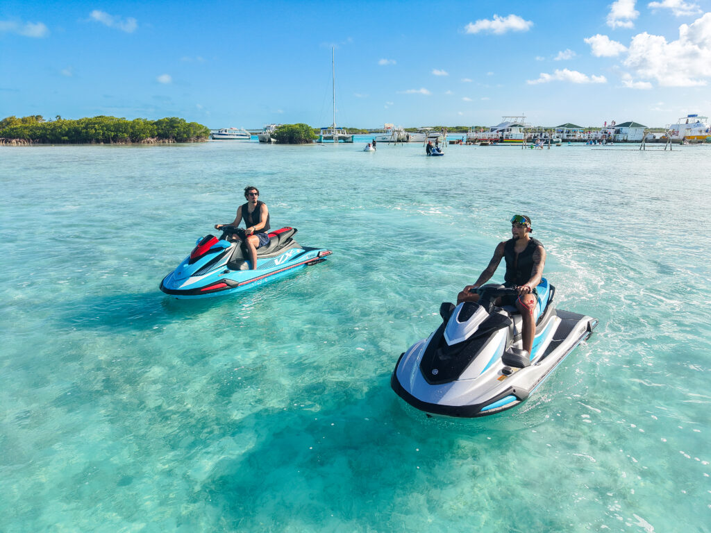 Two jet skis riding together over turquoise shallows