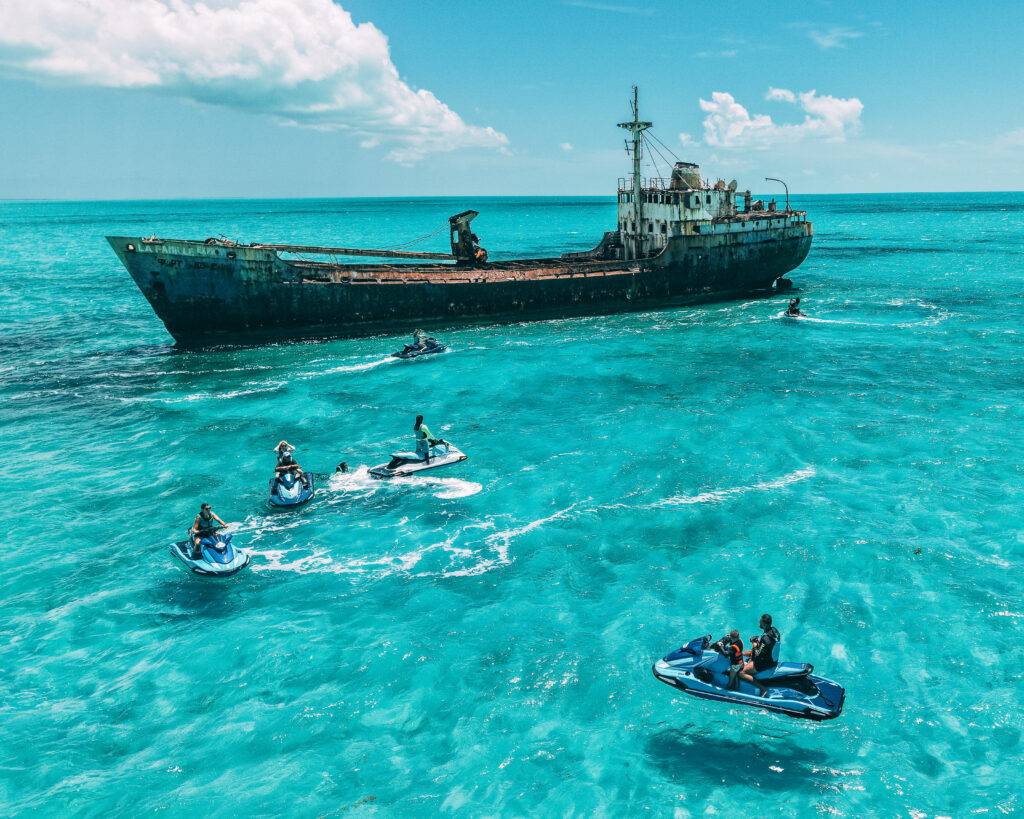 Guided jet ski group riding past a shipwreck in Turks and Caicos