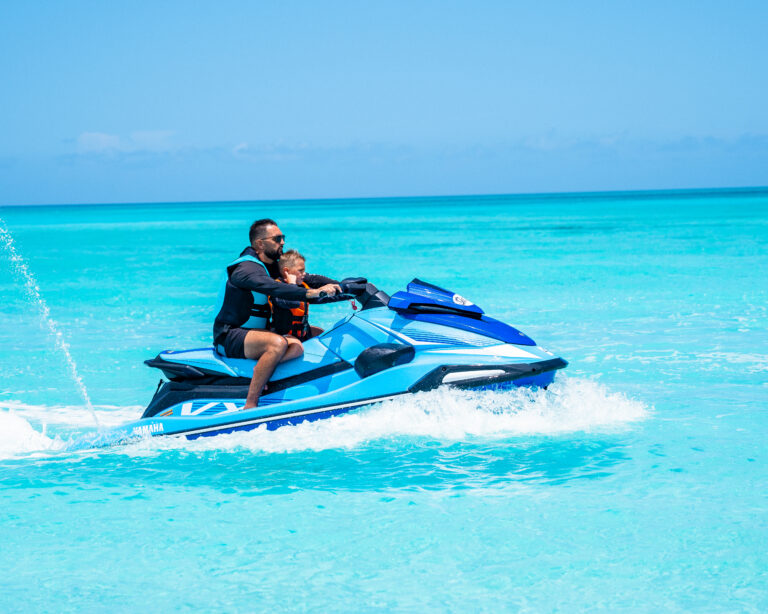 Adult and child riding a jet ski together in Turks and Caicos