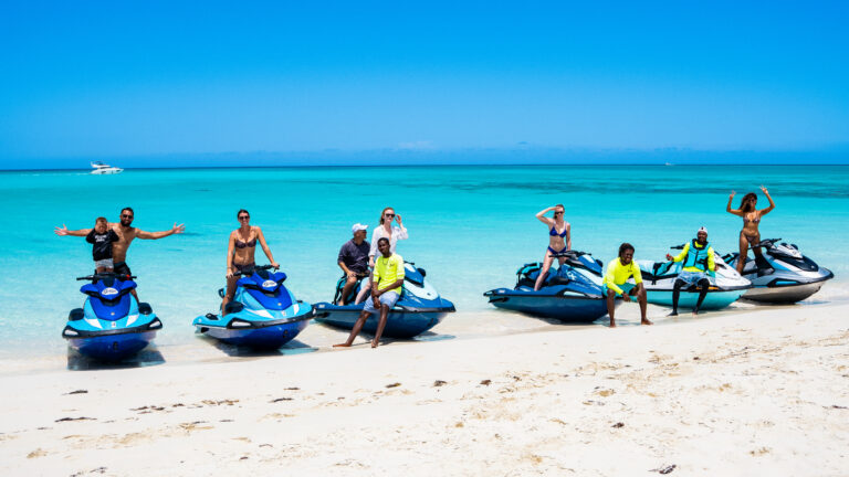 Riders seated on their jet skis on the beach before heading out